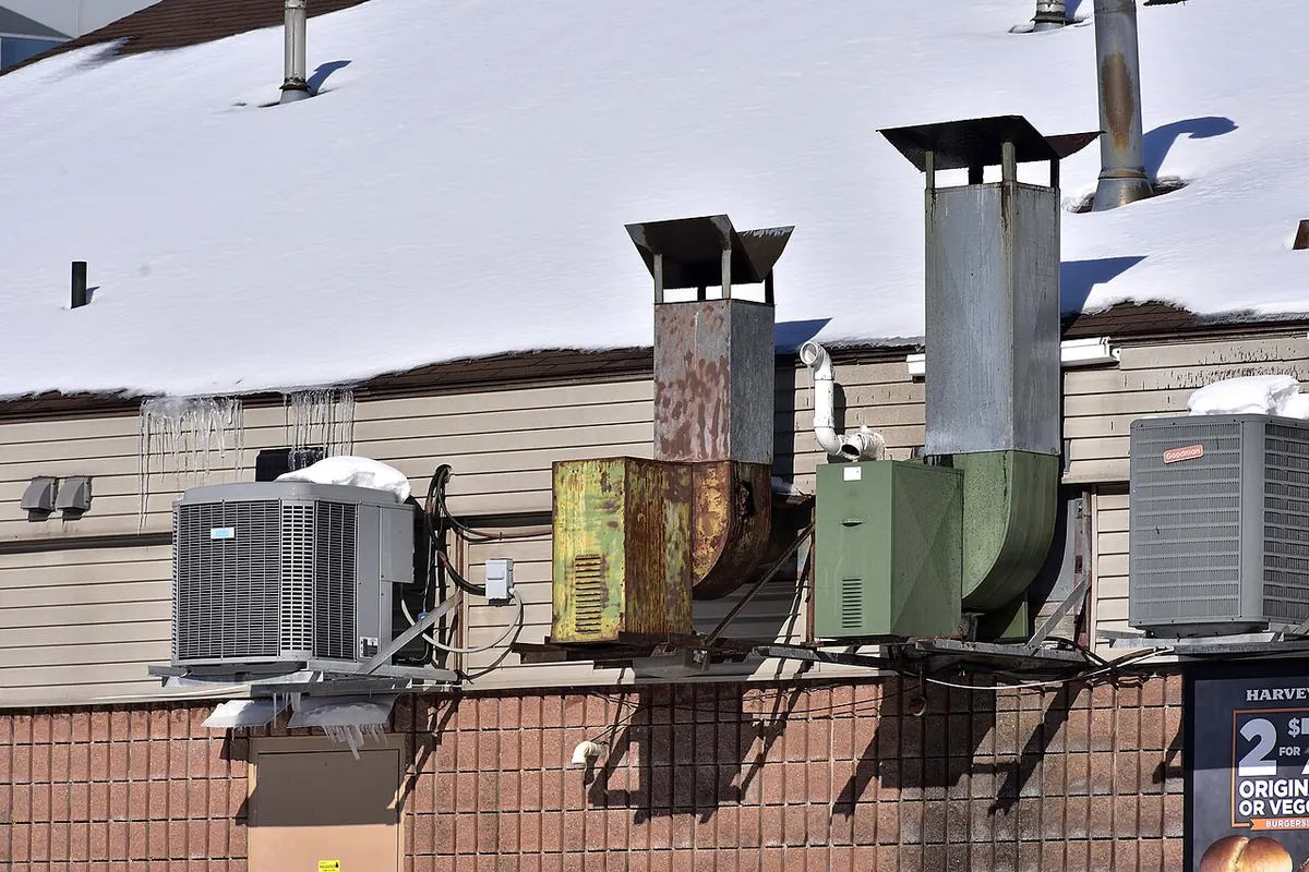 Two ducted centrifugal exhaust fans mounted on the exterior wall of a restaurant building